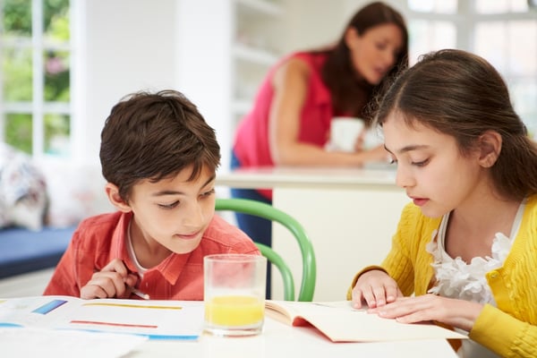 Kids Doing Homeork in the Kitchen, While Mom Supervises