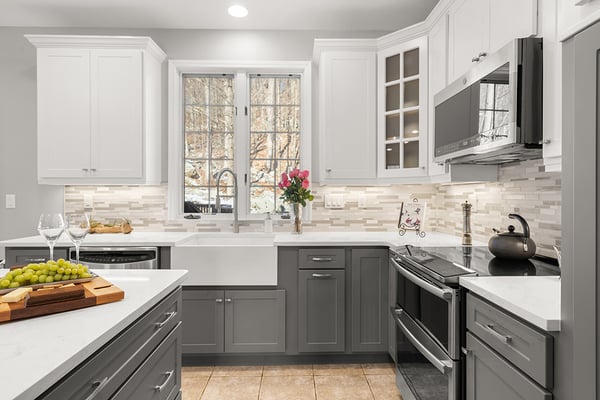 Stainless Steel Side-by-Side French Door Fridge in a Kitchen with Black and Gray Cabinets