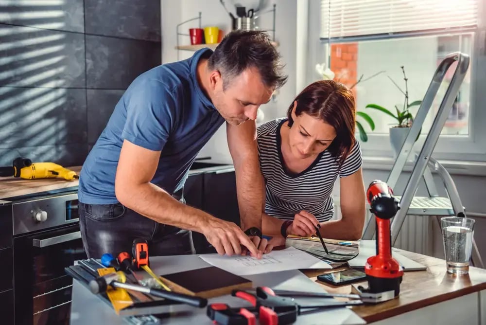 couple reviewing kitchen remodel blueprints during a design consultation